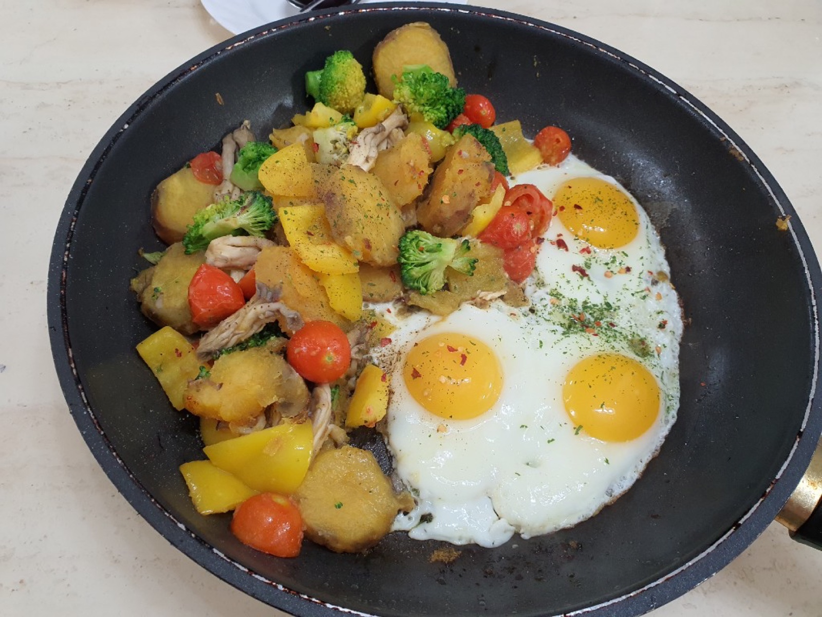 Skillet breakfast with eggs, potatoes, broccoli, and peppers